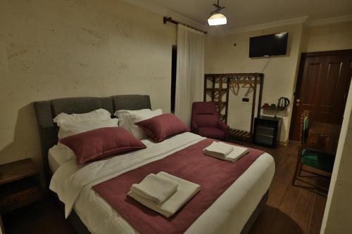 a bedroom with a large bed with two napkins on it at Yellow Stone House in Goreme