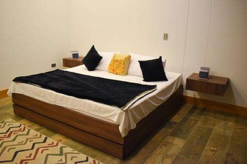 a bedroom with a bed with black and yellow pillows at Montecielo Hosting in Guatapé
