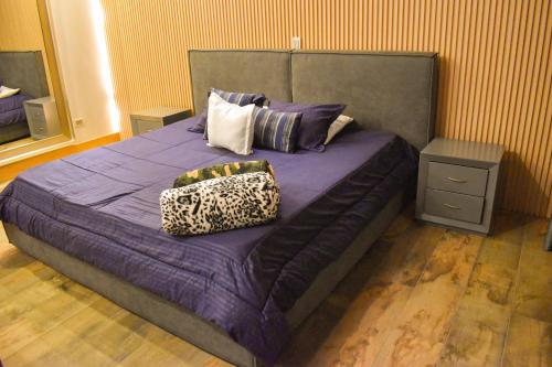 a bedroom with a bed with purple sheets and pillows at Montecielo Hosting in Guatapé