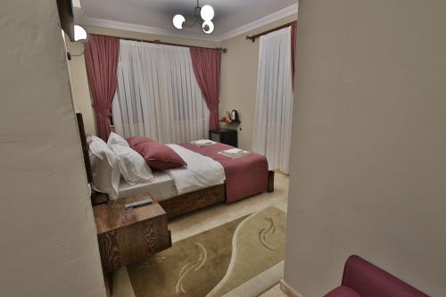 a bedroom with a bed with red curtains at Yellow Stone House in Goreme