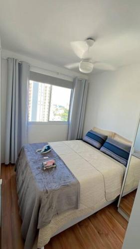 um quarto com uma cama e uma ventoinha de tecto em Chácara Santo Antônio 1 dormitório com sacada em São Paulo