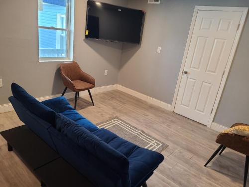 a living room with a blue couch and a flat screen tv at Spacious retreat in Carbondale