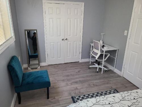 a bedroom with a blue chair and a desk and a mirror at Spacious retreat in Carbondale