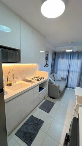 uma cozinha com um lavatório, um fogão e um sofá em Chácara Santo Antônio 1 dormitório com sacada em São Paulo