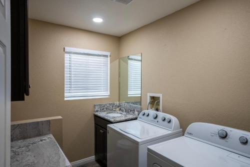 a laundry room with a washing machine and a sink at Modern Desert Delight! 4- bedrooms, pool, gameroom in Lake Havasu City