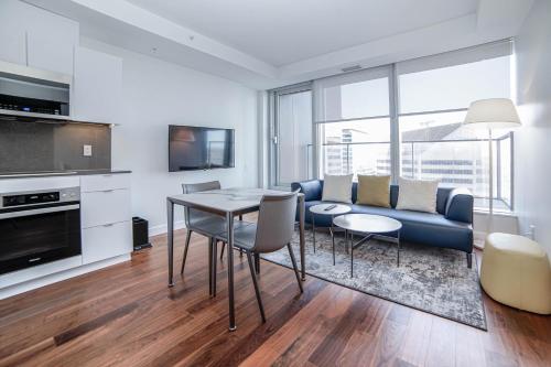 a living room with a couch and a table and chairs at Award-Winning One-Bedroom Suite at Telus Sky in Calgary