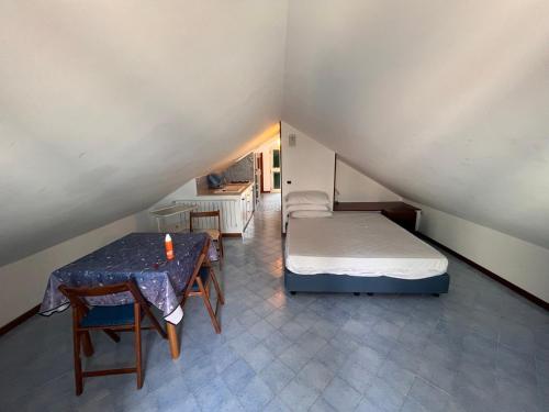 Kleines Zimmer mit einem Bett und einem Tisch in der Unterkunft La Mansarda in Caprioli