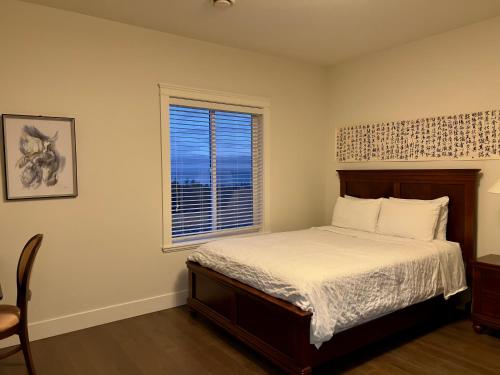 a bedroom with a bed and a window at Ocean Melody Vacation Rooms in Nanaimo