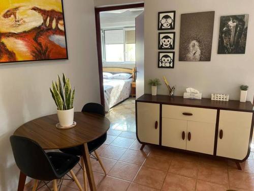 a dining room with a table and a bedroom at A cozy one-bedroom in Heron, Djibouti in La Plaine