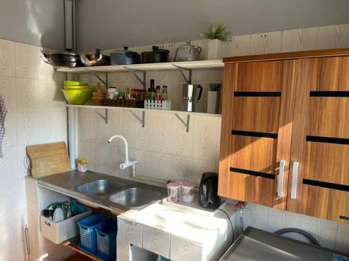 La cuisine est équipée d'un évier et de placards en bois. dans l'établissement A cozy one-bedroom in Heron, Djibouti, à La Plaine