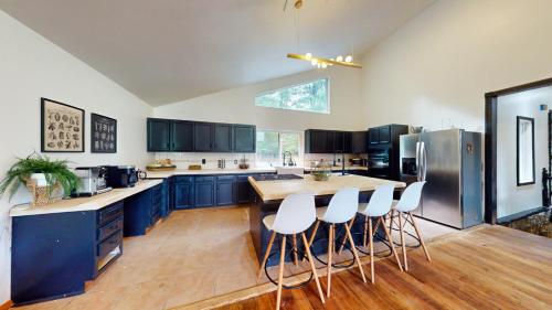 a large kitchen with blue cabinets and white appliances at The Stone Mason - Large Modern Home on 5 Acres - 2 Hrs from NYC in Pond Eddy