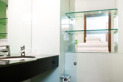 a bathroom with a sink and a mirror at Ramada Encore Leicester City Centre in Leicester