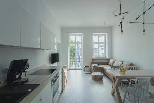 格地尼亞的住宿－Apartment Gdynia Centrum SEA 5 min do morza，厨房以及带沙发和桌子的客厅。