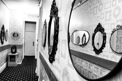 a mirror on a wall with mirrors on a hallway at The Hotel Commodore in Llandrindod Wells