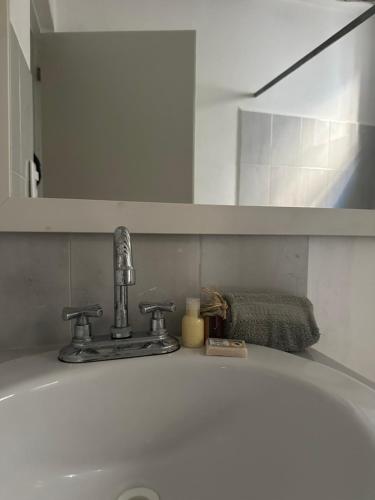 umywalkę z kranem i lustrem w łazience w obiekcie Cuarto chingui w mieście Isla Holbox