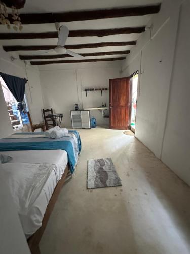 a room with two beds and a rug on the floor at Cuarto chingui in Holbox Island