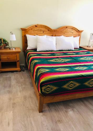 a bedroom with a bed with a colorful blanket at Sunset Inn and Suites in Fredericksburg