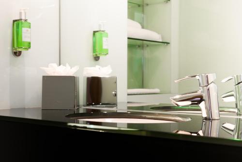 a bathroom with a sink and a mirror at Ramada Encore Leicester City Centre in Leicester