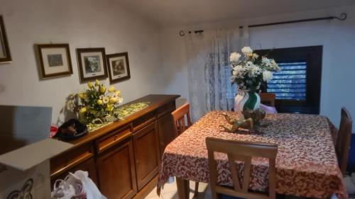 un comedor con una mesa con un jarrón de flores en NOVA DOMUS, en Corfinio