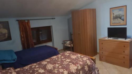 1 dormitorio con 1 cama y vestidor con ordenador portátil en NOVA DOMUS, en Corfinio
