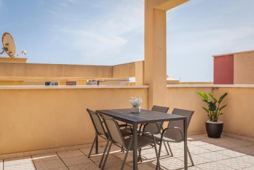 d'une table et de chaises noires sur le balcon. dans l'établissement Apartamento Las Brisas, Atico, à Puerto de Mazarrón