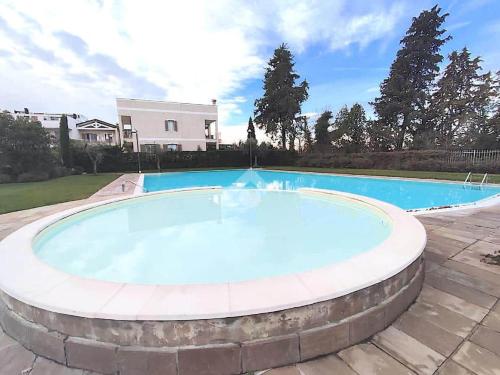 een groot zwembad in een tuin bij Villa Angelina Garda in Cavalcaselle