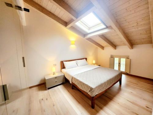 een slaapkamer met een bed en een dakraam bij Villa Angelina Garda in Cavalcaselle