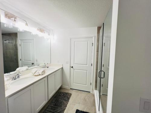 a white bathroom with two sinks and a mirror at Davenport 1 in Davenport