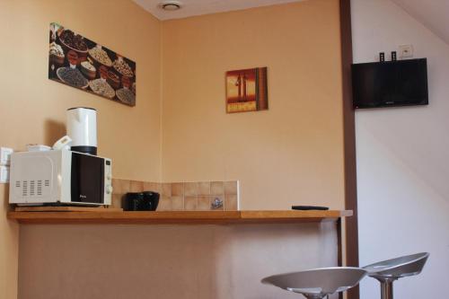 a kitchen with a counter with a microwave and a stool at Mumbasa - Gîtes du Fozo - Herbignac - La Roche Bernard in Herbignac