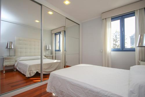 Un dormitorio con dos camas y un espejo. en Luxury apt in Plaza de España - FREE parking, en Sevilla