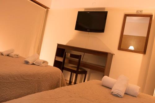 a hotel room with two beds and a flat screen tv at Altair Hotel in San Clemente del Tuyú