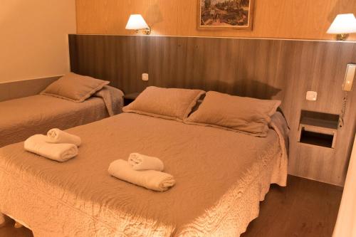 two beds with towels on them in a bedroom at Altair Hotel in San Clemente del Tuyú