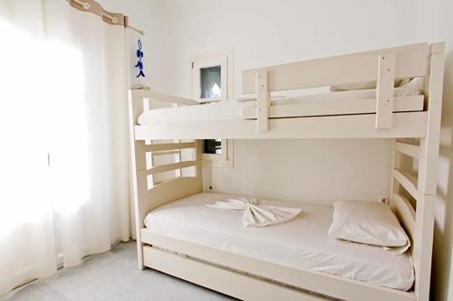 1 dormitorio con literas y paredes blancas en Dolce Vita Waterfront Villa, Logaras, Paros, en Kampos