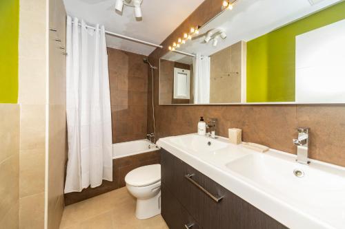 a bathroom with a sink and a toilet and a mirror at Luxury Apartment Chalana in Playa Honda