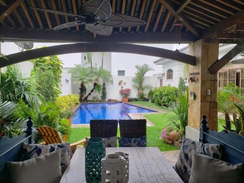 patio con piscina y ventilador de techo en Casa en Samborondón, en Guayaquil