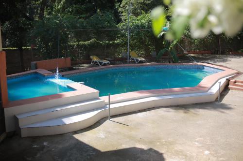 a swimming pool with a fountain in a yard at Lakou Breda in Cap-Haïtien