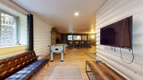 a living room with a couch and a tv on a wall at The Stone Mason - Large Modern Home on 5 Acres - 2 Hrs from NYC in Pond Eddy