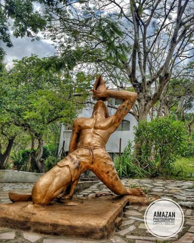 a statue of a man hitting a ball at Lakou Breda in Cap-Haïtien
