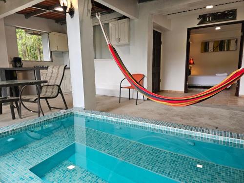 a hammock in the middle of a swimming pool at OLP Treehouse Cerro Azul in Cerro Azul