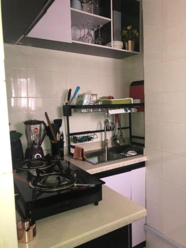 uma cozinha com um lavatório e um fogão forno superior em willy-richy Apartments em Ikeja