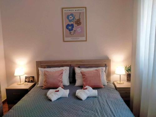 a bedroom with a bed with pillows and two lamps at 2BDR Downtown Veria Peach Blossom in Veria