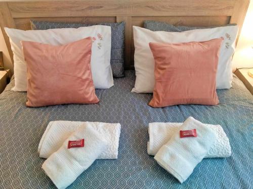 a bed with four pairs of socks and pillows at 2BDR Downtown Veria Peach Blossom in Veria