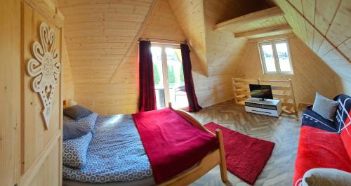 a bedroom with a bed in a wooden cabin at ECO Domek z dużym ogrodem i widokiem in Murzasichle