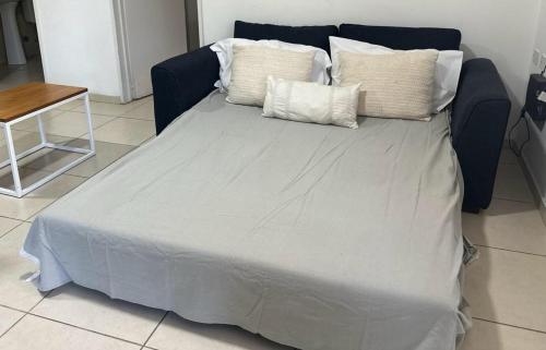 Una cama con cuatro almohadas encima. en Los Zorzales Centro en Mendoza
