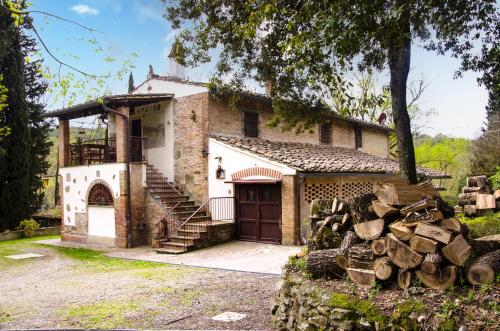 una vecchia casa con un mucchio di tronchi davanti di Il Bosco del Lebbio a Montaione