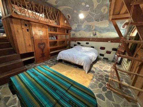 a bedroom with a bed and stairs in a room at Earthship 3 levels apartment starboard cabin with lake view in San Marcos La Laguna