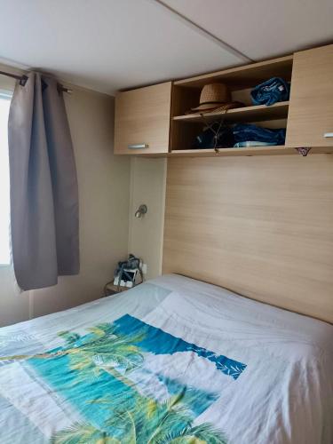 une chambre avec un lit avec une tête de lit en bois dans l'établissement Mobilhome 3 Bedrooms 2 Bathrooms - Camping Familial JF64, aux Mathes