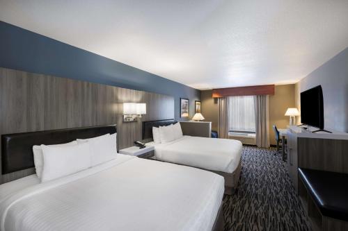 a hotel room with two beds and a flat screen tv at Best Western PLUS Mountain View Auburn Inn in Auburn