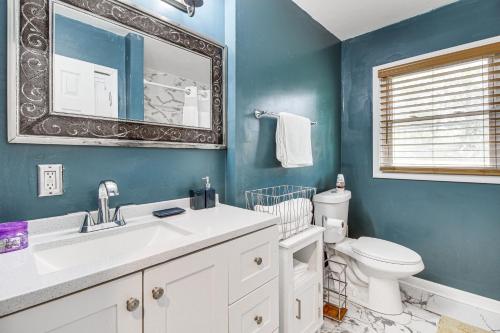een badkamer met een wastafel, een toilet en een spiegel bij Inviting Savannah Home with Yard 3 Mi to Downtown! in Savannah