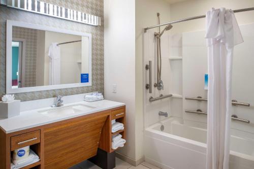 a bathroom with a sink and a tub and a shower at Home2 Suites St. Louis / Forest Park in Richmond Heights